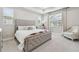 Serene bedroom with a tufted headboard, soft lighting, and a cozy seating area at 33287 Sycamore Leaf Dr, Wesley Chapel, FL 33545
