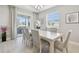 Dining room features a white wood table, seating for six, light-colored walls, and sliding glass doors at 33287 Sycamore Leaf Dr, Wesley Chapel, FL 33545