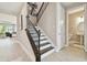 Bright entryway features wood stairs, modern lighting, neutral paint and views into the main living space at 33287 Sycamore Leaf Dr, Wesley Chapel, FL 33545