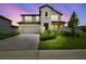 Charming two-story home with a stone facade, two-car garage, and professionally landscaped front yard at 33287 Sycamore Leaf Dr, Wesley Chapel, FL 33545