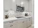 Bright kitchen features modern cabinets, stainless appliances, white countertops and mosaic backsplash at 33287 Sycamore Leaf Dr, Wesley Chapel, FL 33545