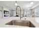 Close-up of kitchen sink features a view into the open concept floor plan and fireplace at 33287 Sycamore Leaf Dr, Wesley Chapel, FL 33545