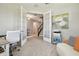 Elegant home office with french doors leading to a hallway with stairs and a painting at 33287 Sycamore Leaf Dr, Wesley Chapel, FL 33545