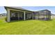 Covered patio and screened-in lanai create an ideal outdoor living space surrounded by green grass at 33287 Sycamore Leaf Dr, Wesley Chapel, FL 33545