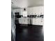 A bright kitchen with white cabinetry and stainless steel appliances over dark-stained hardwood floors at 4049 Ponea Dr, Sarasota, FL 34241