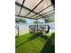 Covered patio features artificial turf and a dining table with chairs at 4049 Ponea Dr, Sarasota, FL 34241