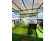 Covered patio features artificial turf and a dining table with chairs at 4049 Ponea Dr, Sarasota, FL 34241