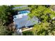 Aerial view of home with pool and screened-in enclosure in treed neighborhood at 415 Mission Hills Ave, Temple Terrace, FL 33617