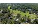 Scenic aerial view of the golf course and homes, surrounded by lush greenery and a pond at 415 Mission Hills Ave, Temple Terrace, FL 33617