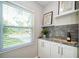 Stylish bar area with sleek cabinetry, backsplash, and shelving providing the perfect nook to unwind at 415 Mission Hills Ave, Temple Terrace, FL 33617