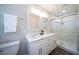 Updated bathroom with dual sinks, a white vanity, and a walk-in shower with glass door at 415 Mission Hills Ave, Temple Terrace, FL 33617
