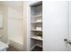 Bathroom linen closet with shelves and tiled shower with glass doors at 415 Mission Hills Ave, Temple Terrace, FL 33617