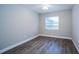 Cozy bedroom with wood-look floors, natural light, and neutral paint scheme for easy customization at 415 Mission Hills Ave, Temple Terrace, FL 33617