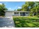 Charming home features a well-manicured lawn and beautiful landscaping at 415 Mission Hills Ave, Temple Terrace, FL 33617