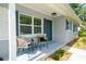 Charming front porch with seating area, gray siding, and well-maintained landscaping at 415 Mission Hills Ave, Temple Terrace, FL 33617