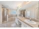 Luxurious bathroom with dual sinks, a large mirror, a glass-enclosed shower, and a soaking tub at 419 Stone Briar Dr, Ruskin, FL 33570