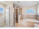Bathroom featuring a glass shower enclosure, a soaking tub, and a window with a decorative arch at 419 Stone Briar Dr, Ruskin, FL 33570
