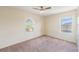 Neutral bedroom with a ceiling fan, carpet and two arched windows at 419 Stone Briar Dr, Ruskin, FL 33570