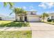 Charming two-story home with a well-manicured lawn, mature palms, and a two-car garage at 419 Stone Briar Dr, Ruskin, FL 33570