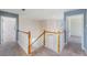 Upstairs hallway with carpet, white railings, and two open doorways at 419 Stone Briar Dr, Ruskin, FL 33570