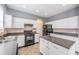 White kitchen cabinets, center island, and black appliances with neutral backsplash at 419 Stone Briar Dr, Ruskin, FL 33570
