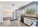 Kitchen with an island, white cabinetry, black appliances, and a view into the living room at 419 Stone Briar Dr, Ruskin, FL 33570