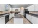 Bright kitchen with white cabinets, black appliances, and a center island, and tile floors at 419 Stone Briar Dr, Ruskin, FL 33570