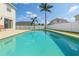 Refreshing in-ground pool surrounded by a white fence and lush tropical landscaping at 419 Stone Briar Dr, Ruskin, FL 33570