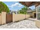Private courtyard with gray and white pavers, stucco wall and gate to neighboring houses at 4463 Vieux Carre Cir, Tampa, FL 33613