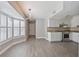 Open-concept kitchen with white cabinets, granite countertops, tile backsplash, stainless steel appliances, and tiled floors at 4463 Vieux Carre Cir, Tampa, FL 33613