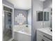 Well-lit bathroom featuring a shower, white tub, glass block window, and modern fixtures at 4464 Neptune Dr, Hernando Beach, FL 34607