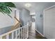 Inviting hallway featuring light blue walls, hardwood floors, and a staircase with white railings at 4464 Neptune Dr, Hernando Beach, FL 34607
