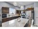 Open kitchen with stone countertops, stainless steel appliances, and dark wood cabinets with island at 4464 Neptune Dr, Hernando Beach, FL 34607