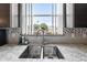 Kitchen sink and granite countertops under large window, providing natural light and pleasant views at 4464 Neptune Dr, Hernando Beach, FL 34607
