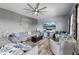 Spacious living room with a large gray sectional, modern ceiling fan, and stylish decor creating an inviting space at 4464 Neptune Dr, Hernando Beach, FL 34607