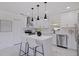 Bright kitchen featuring white cabinetry, stainless steel appliances, a stylish island, and modern pendant lighting at 4609 S Shamrock Rd, Tampa, FL 33611