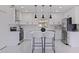 Modern kitchen featuring sleek white cabinets, stainless steel appliances, and a stylish center island at 4609 S Shamrock Rd, Tampa, FL 33611