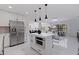 Bright modern kitchen features stainless steel appliances, white cabinetry and an island open to the living area at 4609 S Shamrock Rd, Tampa, FL 33611