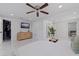 The primary bedroom with a ceiling fan, a TV, a walk-in closet, and elegant marble tile flooring at 4609 S Shamrock Rd, Tampa, FL 33611