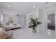 A stylish main bedroom featuring bright white walls, a fan, large mirror, and elegant marble tile flooring at 4609 S Shamrock Rd, Tampa, FL 33611