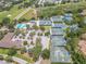 Overhead image displays community tennis courts, a pool with lounge chairs, parking spaces, and surrounding greenery at 465 Holly Hill Rd, Oldsmar, FL 34677