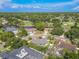 Aerial view featuring the house in a lush, green neighborhood, with a golf course and pond in the background at 465 Holly Hill Rd, Oldsmar, FL 34677