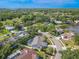 An aerial view of a light blue house with a screened in pool on a well-manicured lawn surrounded by mature trees at 465 Holly Hill Rd, Oldsmar, FL 34677