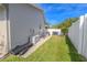 Side yard of home with well-maintained grass and white vinyl fence at 465 Holly Hill Rd, Oldsmar, FL 34677