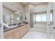 Bright bathroom featuring a double vanity, soaking tub, and a separate glass enclosed shower at 465 Holly Hill Rd, Oldsmar, FL 34677