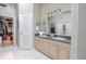 Bright bathroom with double vanity, framed mirrors, tiled shower walls, and walk-in closet at 465 Holly Hill Rd, Oldsmar, FL 34677
