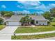 Charming single-story home featuring a well-manicured lawn, mature tree, and inviting front entrance at 465 Holly Hill Rd, Oldsmar, FL 34677