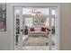 View through glass paneled doors of a living room with sitting area and built-in shelving at 465 Holly Hill Rd, Oldsmar, FL 34677