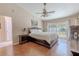 Bright main bedroom with ceiling fan, wood floors, and sliding glass doors to the backyard at 465 Holly Hill Rd, Oldsmar, FL 34677