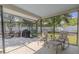 Screened-in patio with cozy seating area, barbeque, and views of the fenced backyard at 465 Holly Hill Rd, Oldsmar, FL 34677